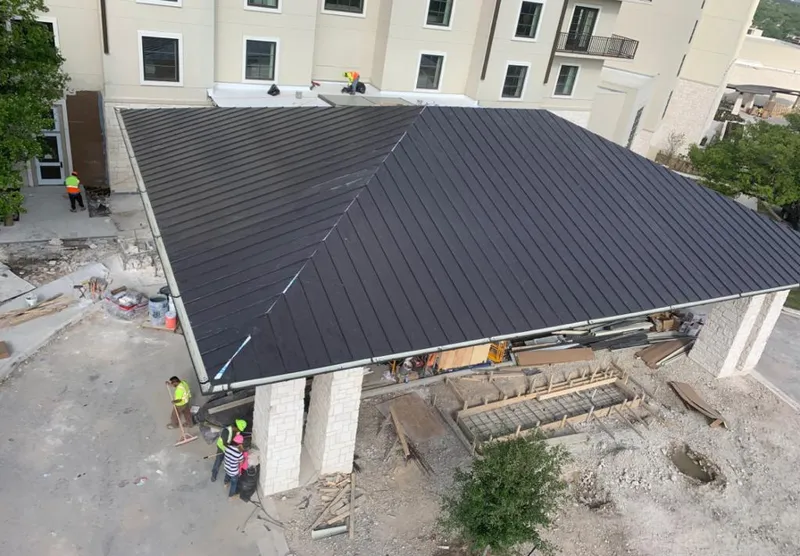 Metal roofing installation team working on a commercial building in Red Oak